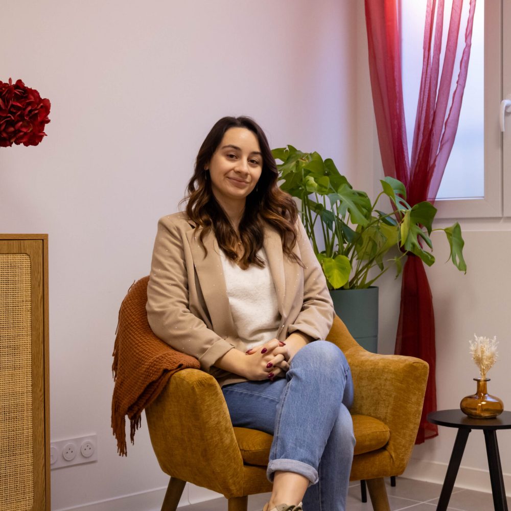 Vérane Geronimi, praticienne en hypnose, assise dans un fauteuil dans son cabinet à Colomiers, à l'écoute, dans une posture détendue